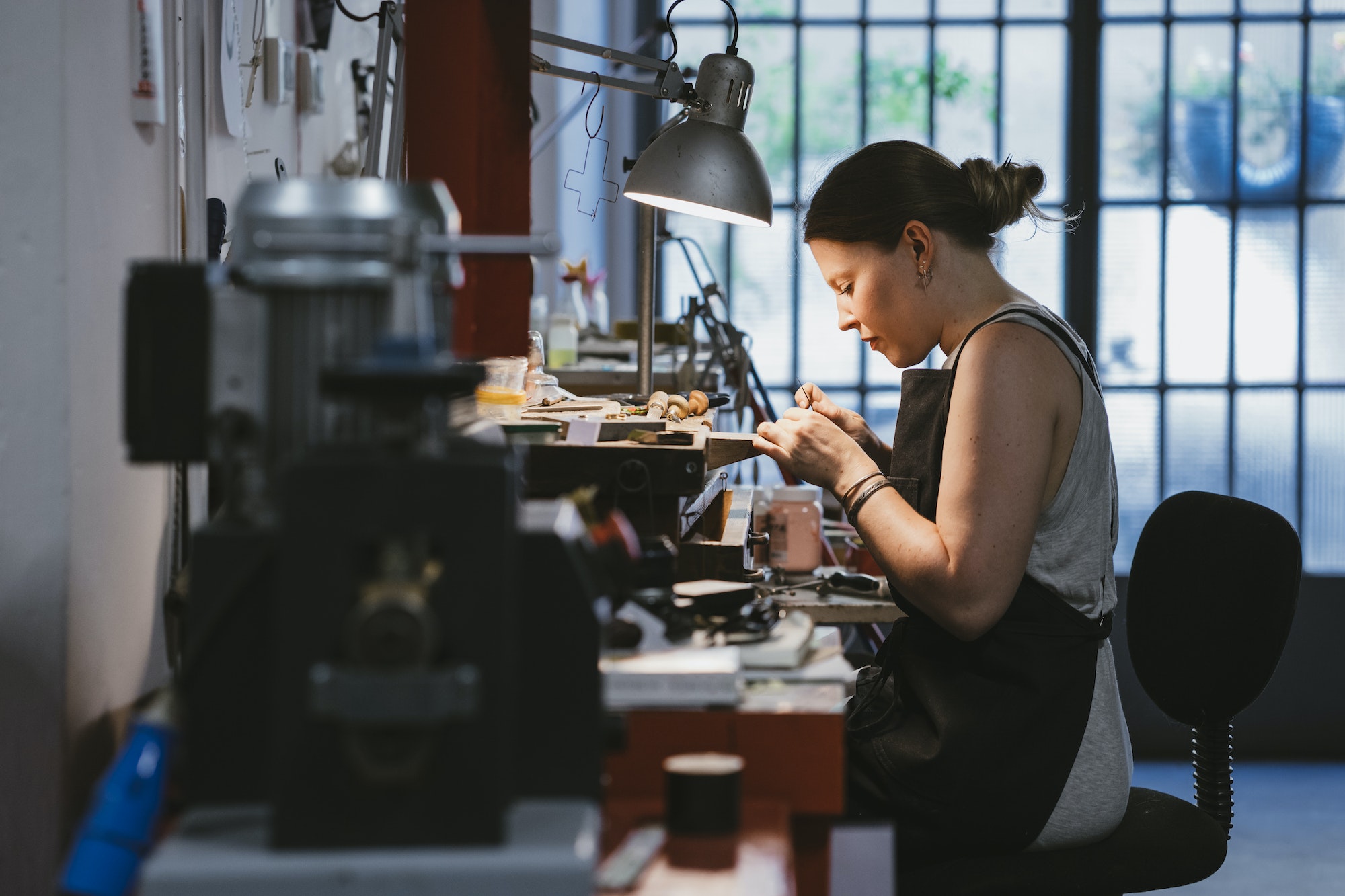 Female jeweller at work in jewellery workshop